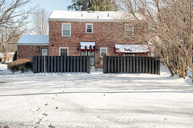 view of snow covered back of property