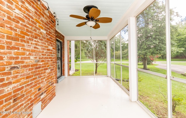 unfurnished sunroom with ceiling fan