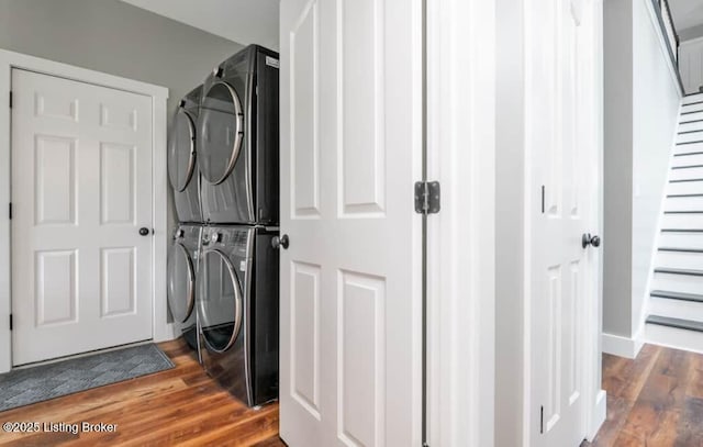 washroom featuring stacked washer and dryer and wood-type flooring