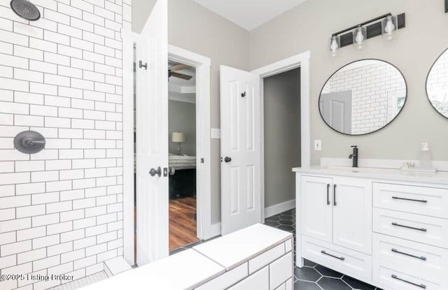 bathroom with tiled shower, vanity, and tile patterned floors