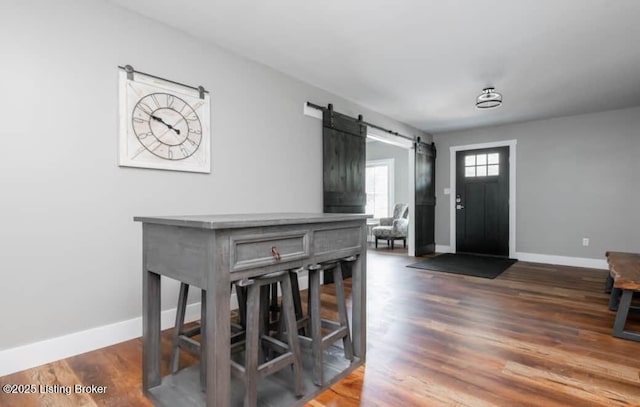 dining room featuring dark hardwood / wood-style floors and a barn door