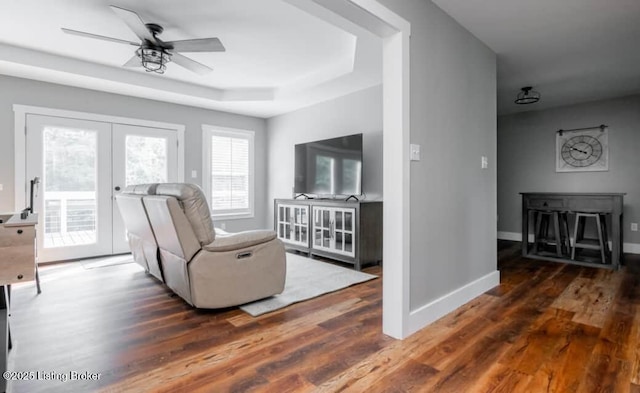 living room featuring french doors, dark hardwood / wood-style flooring, a raised ceiling, and ceiling fan