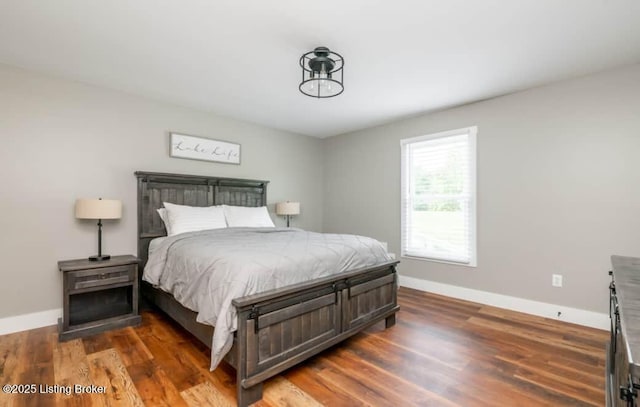 bedroom with dark hardwood / wood-style flooring