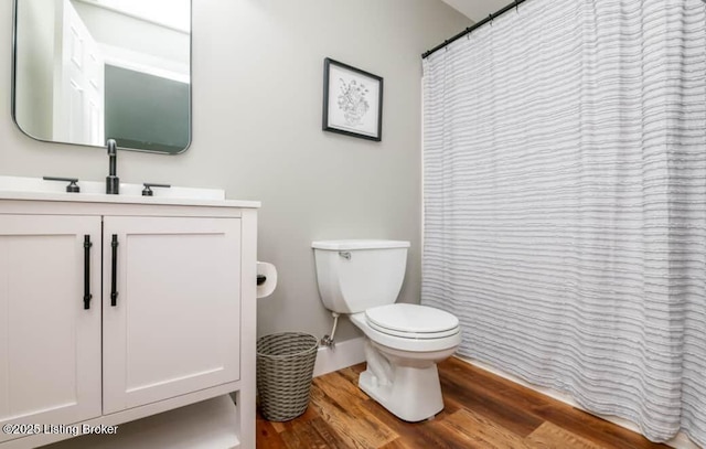 bathroom with hardwood / wood-style flooring, vanity, and toilet