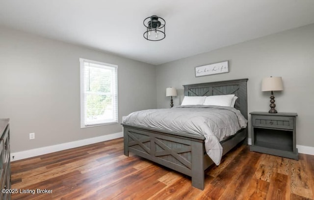 bedroom with dark hardwood / wood-style floors