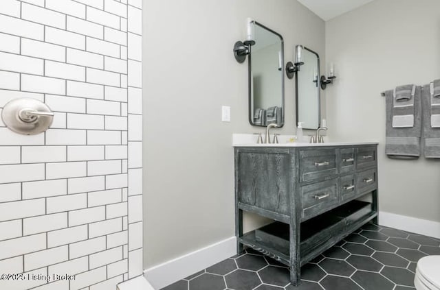 bathroom with toilet, vanity, tile patterned floors, and walk in shower