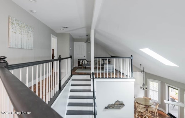 hallway featuring vaulted ceiling with skylight