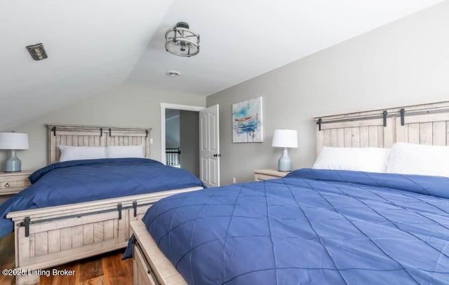 bedroom with dark hardwood / wood-style flooring and lofted ceiling