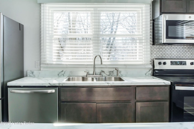 kitchen featuring appliances with stainless steel finishes, tasteful backsplash, sink, and dark brown cabinetry