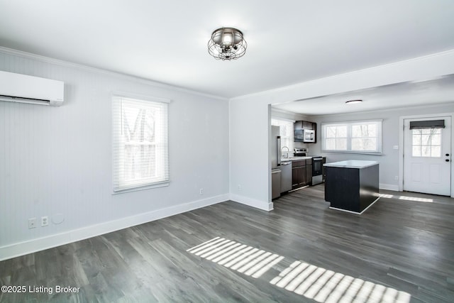 kitchen featuring a wall mounted AC, plenty of natural light, a kitchen island, and stainless steel appliances