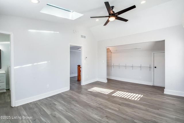 unfurnished living room with dark wood-type flooring, ceiling fan, and lofted ceiling with skylight