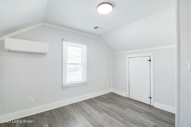 bonus room featuring hardwood / wood-style floors, a wall mounted air conditioner, and vaulted ceiling