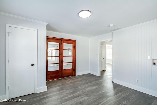 spare room with ornamental molding, dark hardwood / wood-style flooring, french doors, and a wealth of natural light