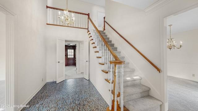 stairs with crown molding, a chandelier, and carpet floors