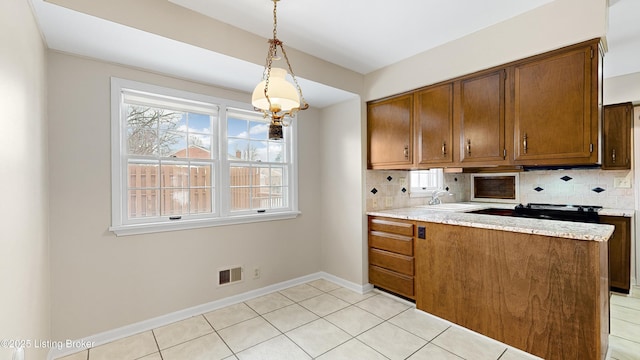 kitchen featuring sink, pendant lighting, backsplash, and light tile patterned floors