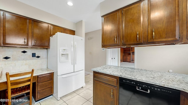 kitchen featuring light tile patterned flooring, tasteful backsplash, black dishwasher, light stone countertops, and white refrigerator with ice dispenser