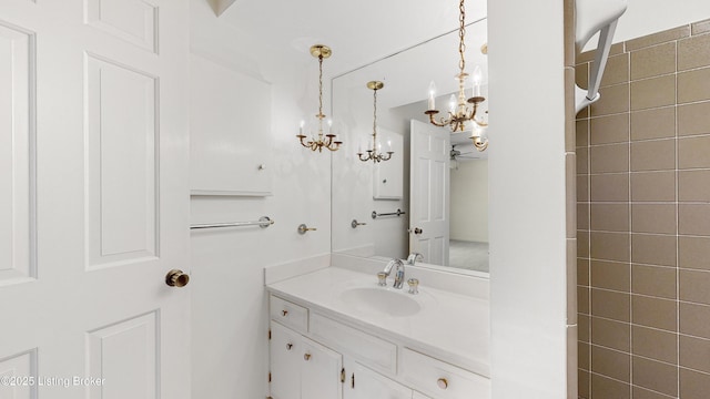 bathroom featuring walk in shower, vanity, and a chandelier