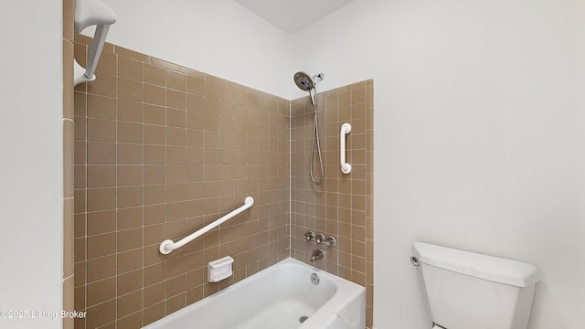 bathroom featuring tiled shower / bath combo and toilet