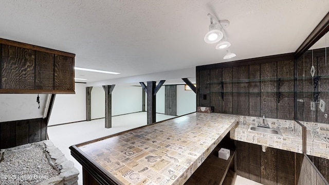 kitchen with dark brown cabinets, sink, and a textured ceiling