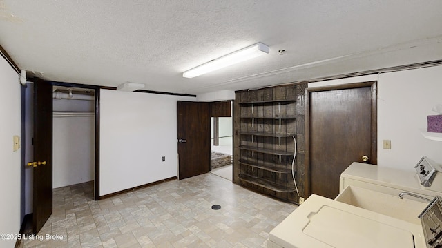 laundry area featuring washer / clothes dryer and a textured ceiling