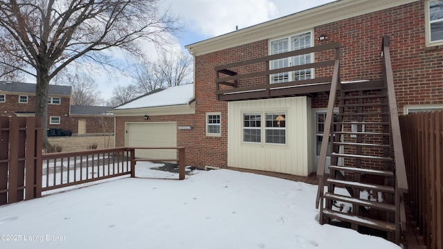 snow covered house featuring a garage