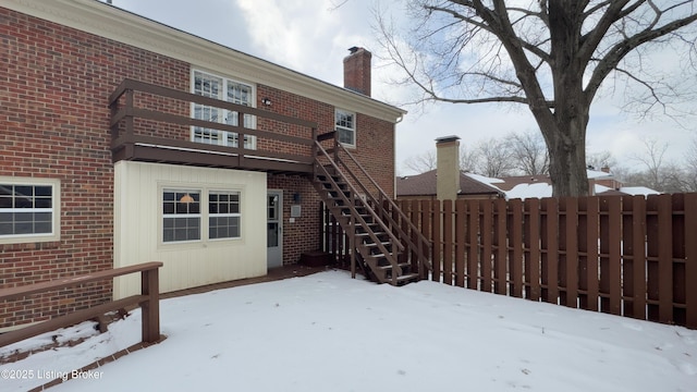 view of snow covered back of property