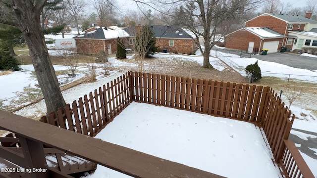 snowy yard featuring a garage