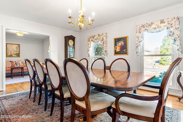 dining space featuring a notable chandelier, crown molding, and wood-type flooring