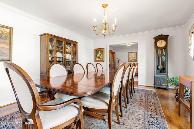 dining area featuring crown molding, a notable chandelier, and dark hardwood / wood-style flooring