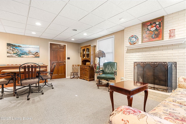 living room with a fireplace, carpet floors, and a paneled ceiling