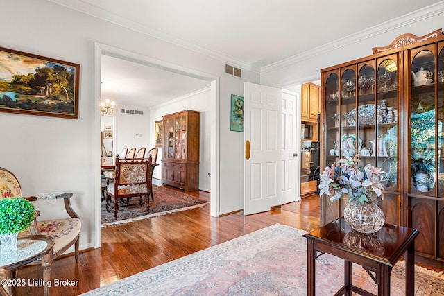 interior space with crown molding, hardwood / wood-style flooring, and a chandelier