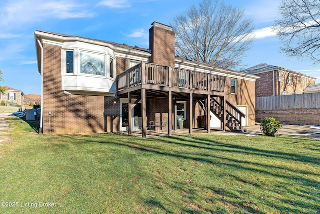 rear view of property with a yard and a deck