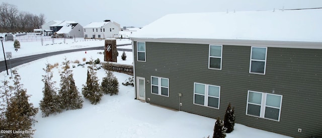 view of snow covered rear of property