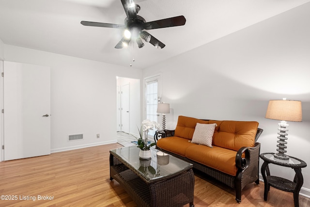 living room featuring ceiling fan and light hardwood / wood-style flooring