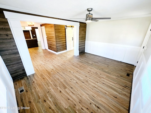 empty room featuring crown molding, wood-type flooring, and ceiling fan