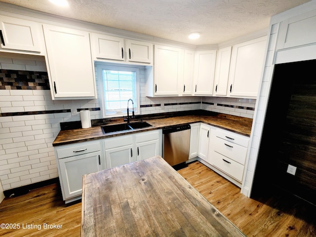 kitchen with wood counters, dishwasher, sink, white cabinets, and light hardwood / wood-style floors