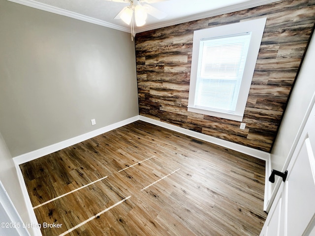 empty room featuring hardwood / wood-style flooring, ceiling fan, crown molding, and log walls