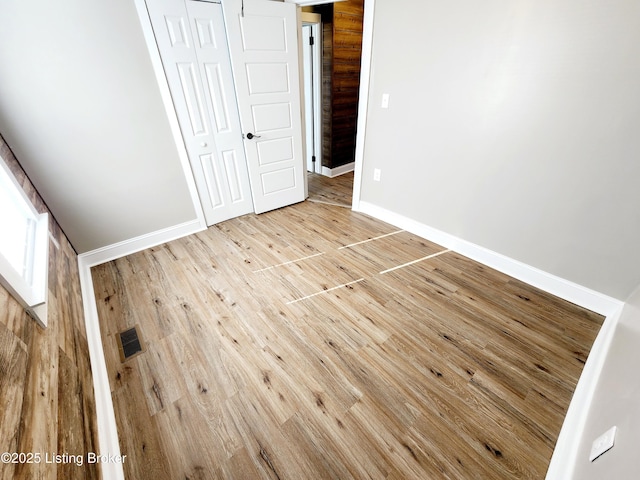 unfurnished bedroom with a closet and light wood-type flooring