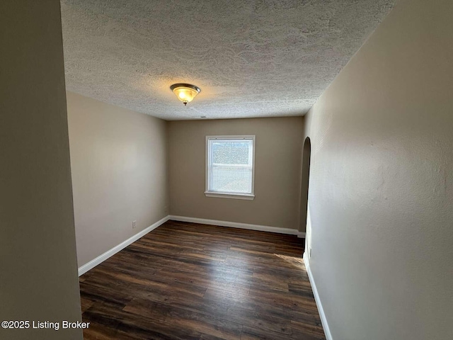 unfurnished room featuring dark hardwood / wood-style floors and a textured ceiling