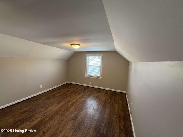 bonus room with dark hardwood / wood-style floors and vaulted ceiling