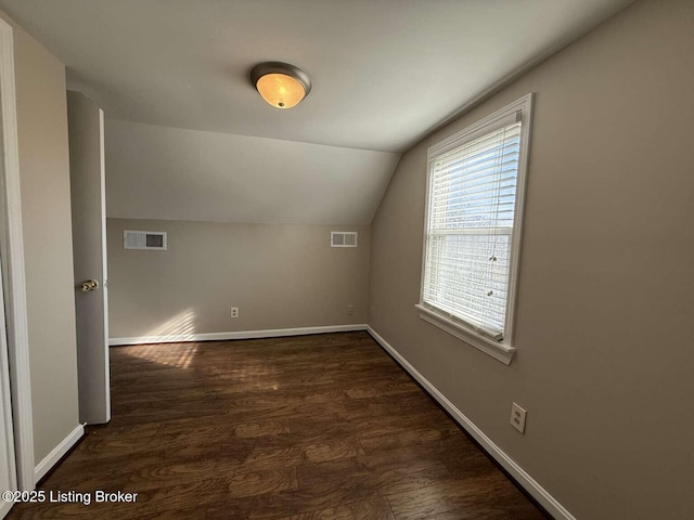 additional living space featuring dark hardwood / wood-style flooring and vaulted ceiling