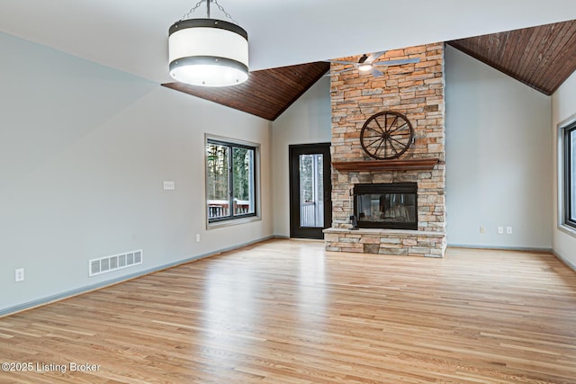 unfurnished living room with ceiling fan, a stone fireplace, high vaulted ceiling, wood ceiling, and light wood-type flooring