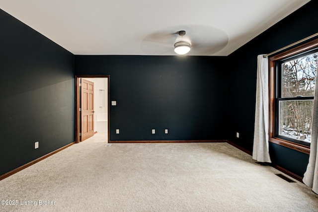 unfurnished room with ceiling fan and light colored carpet