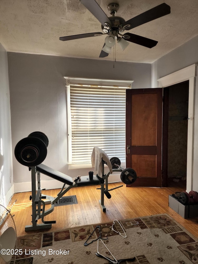 workout area with hardwood / wood-style floors and a textured ceiling