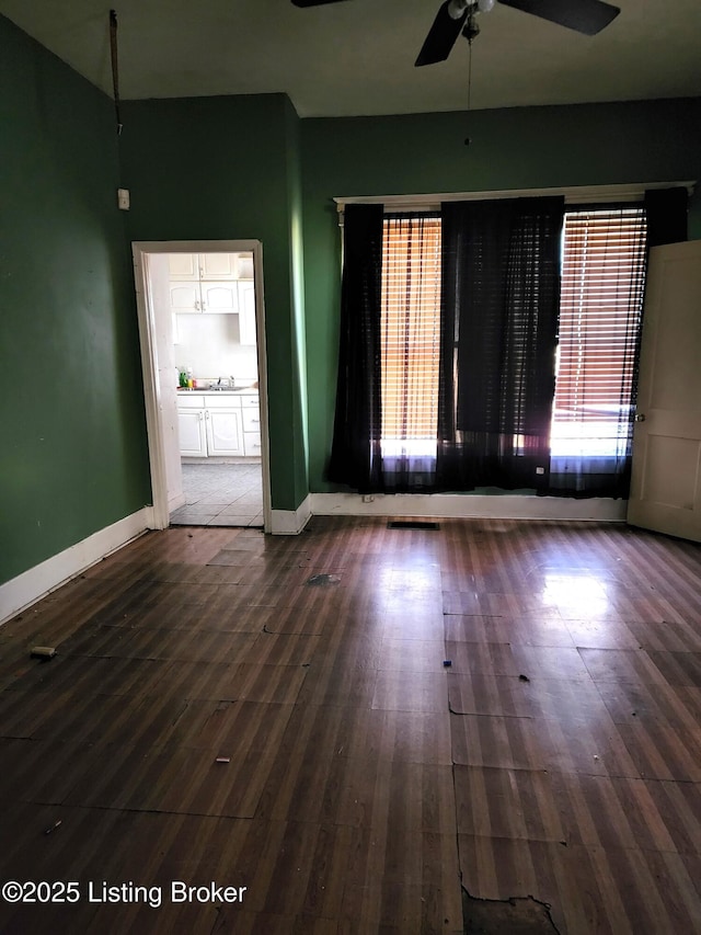 empty room with dark hardwood / wood-style flooring, sink, and ceiling fan