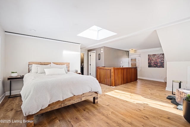 bedroom featuring a skylight and hardwood / wood-style flooring