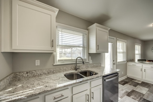 kitchen featuring sink, white cabinetry, stainless steel dishwasher, and light stone countertops