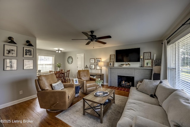 living room with a brick fireplace, ceiling fan, and hardwood / wood-style flooring