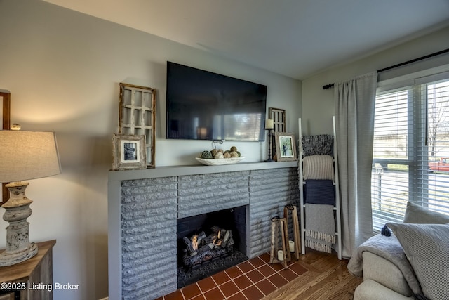 living room featuring a brick fireplace and wood-type flooring