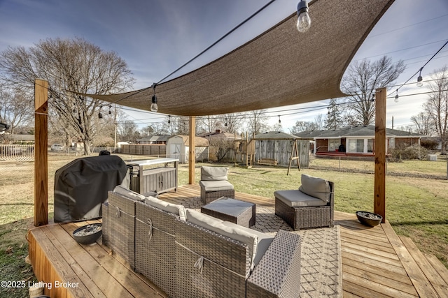 wooden deck featuring a lawn, grilling area, outdoor lounge area, and a shed